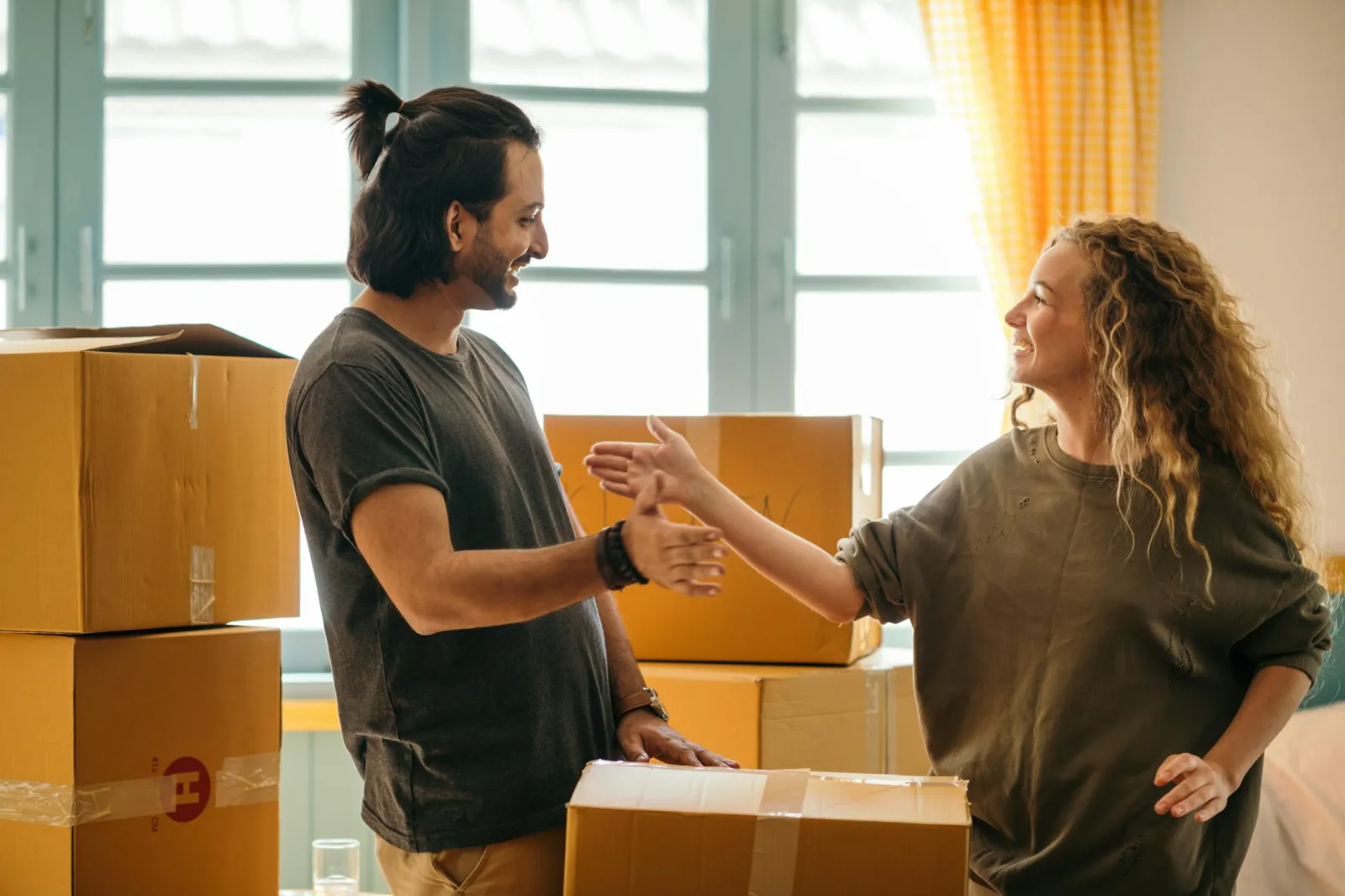 Happy couple unpacking boxes in their new home
