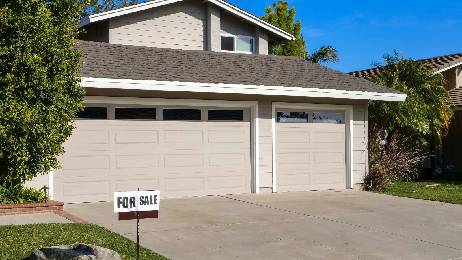House with for sale sign in front yard