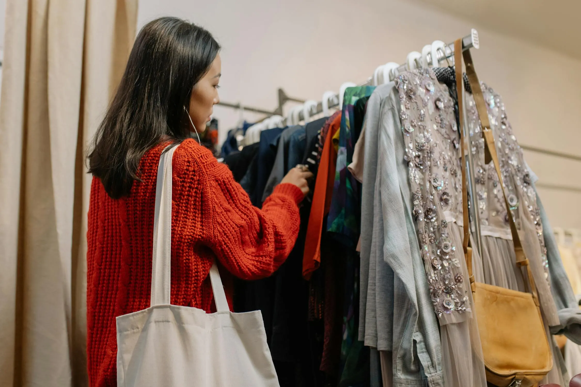 Young woman browsing vintage clothes at a thrift store in Rutland