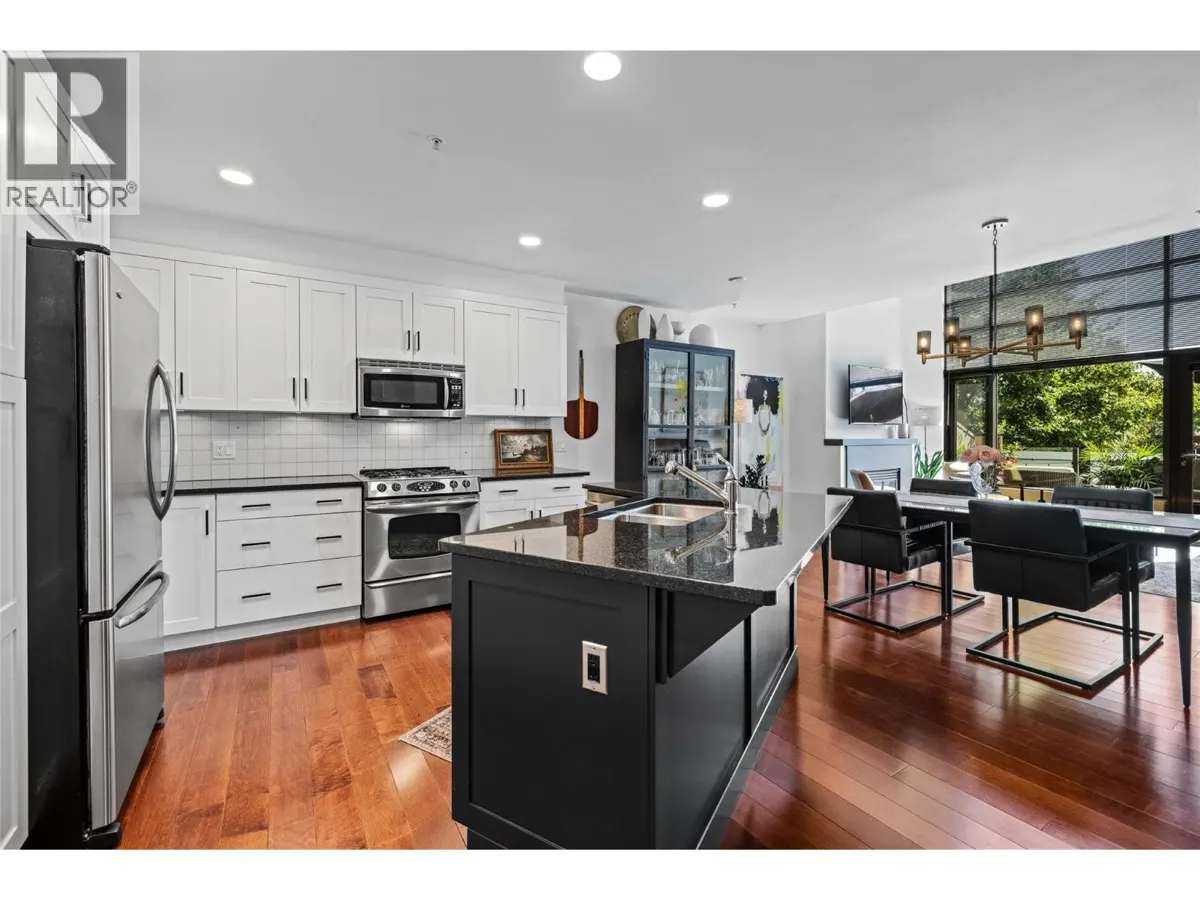 600 Sarsons Road Unit 205 modern kitchen with white cabinets, black island, and granite counters