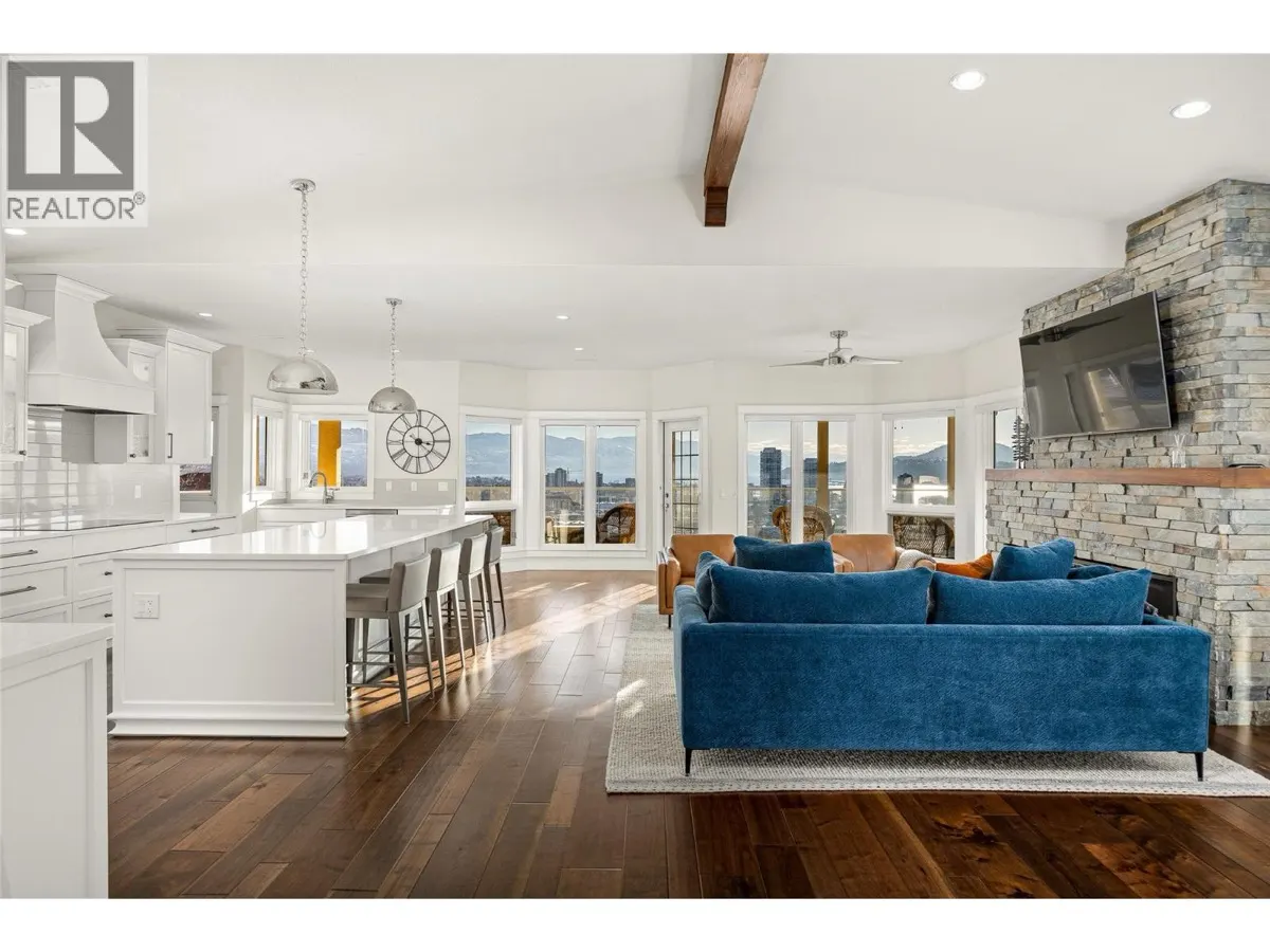 647 Royal Pine Drive open concept living and kitchen with stone fireplace and lake views