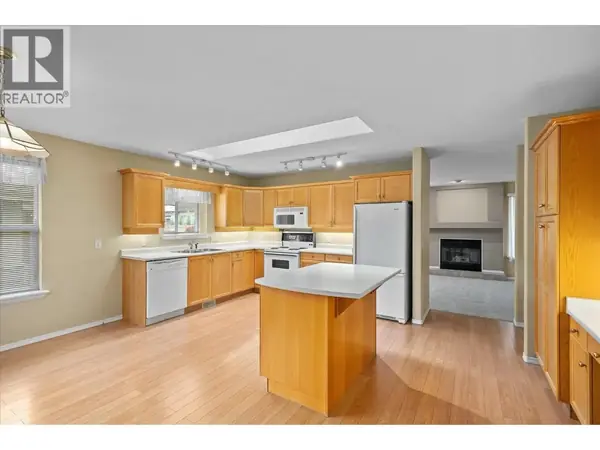 680 Valley Road Unit 12 kitchen with oak cabinets and island opening to living room