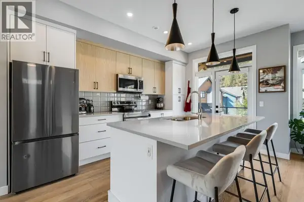 1435 Cara Glen Court Unit 101 modern kitchen with two-tone cabinets and quartz island
