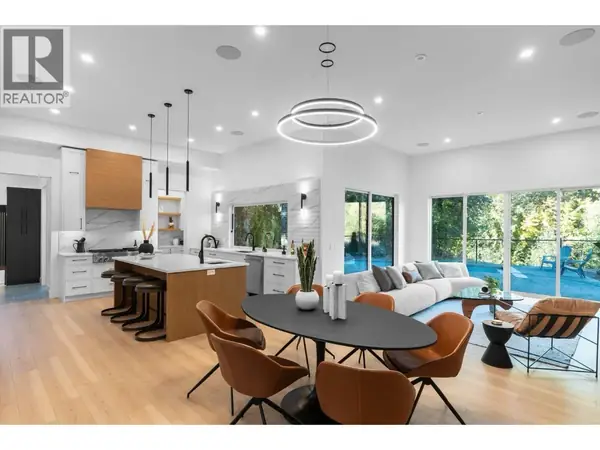 4630 McClure Road open concept kitchen, dining and living area with modern ring chandelier and pool views